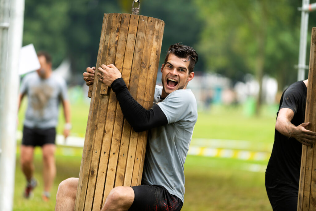 Man die aan houten obstakel hangt. Foto voor obstacle run tips voor beginners strong viking